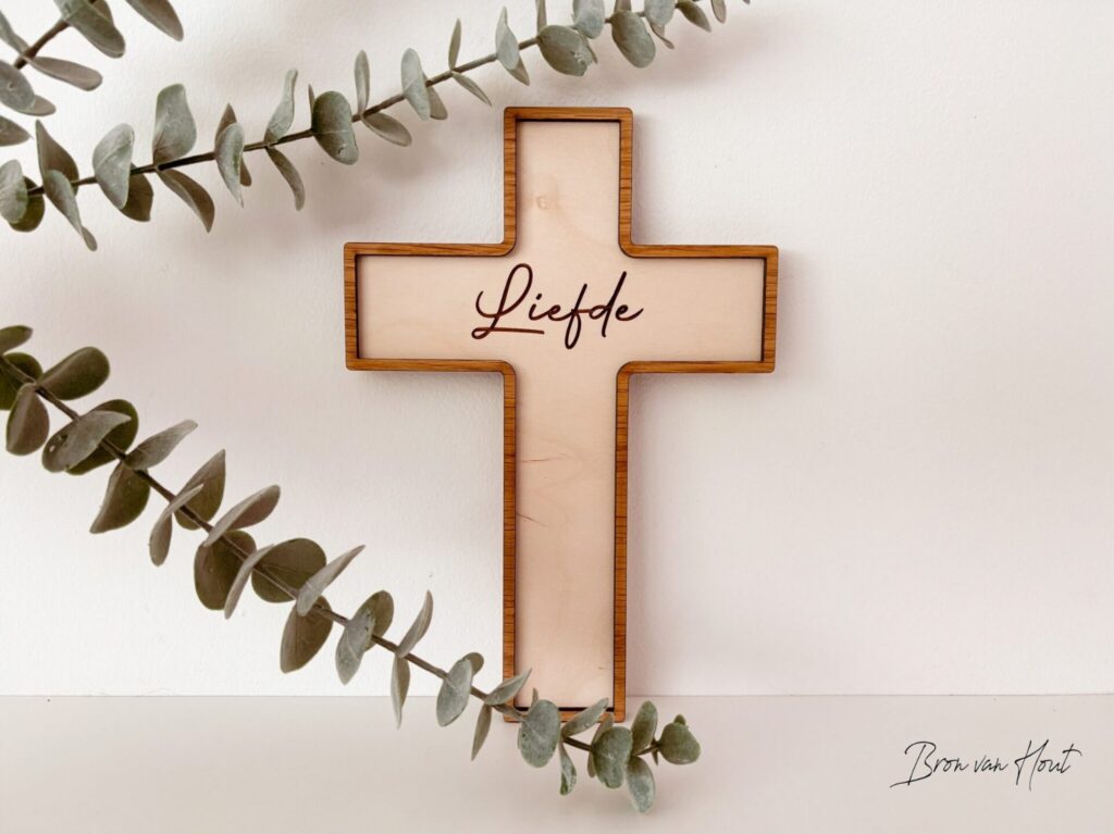 Houten kruis met het woord Liefde, tussen eucalyptus
